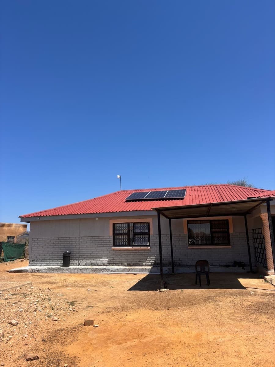 Rural home with solar panels on red roof